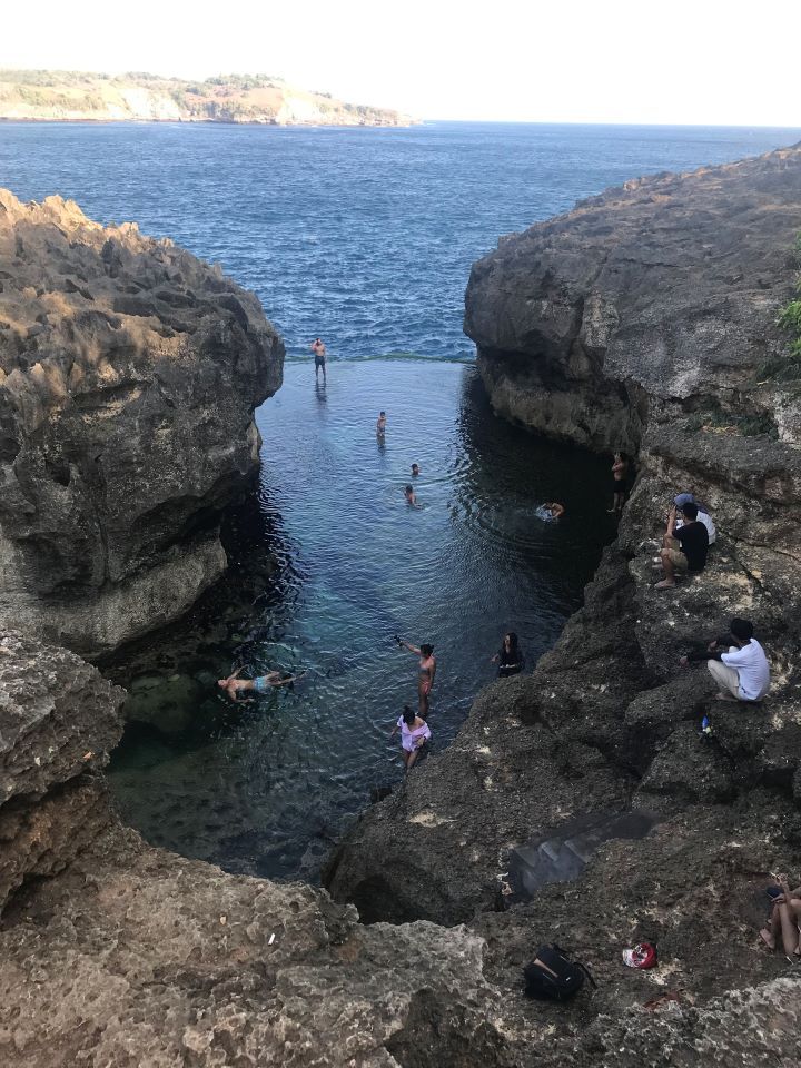 ruta por indonesia gente bañándose en una piscina natural del mar entre rocas